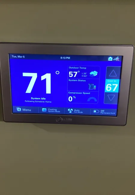 Digital thermostat showing indoor temperature 71°F, outdoor 57°F, system idle, and cooling mode active.