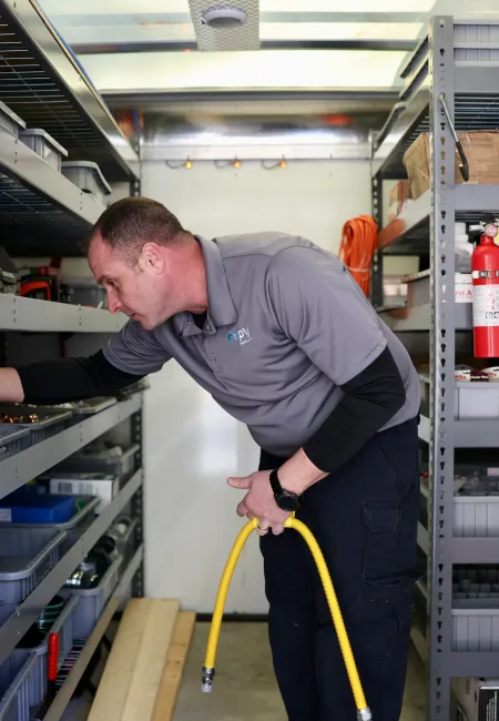 A technician organizing tools and supplies inside a mobile workshop cabinet.
