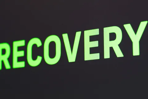 Green glowing text reading RECOVERY on a dark background symbolizing health or data restoration.