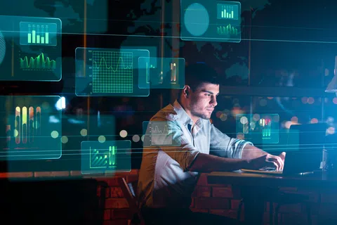 Man working on laptop with futuristic digital analytics and data visualization graphics around him