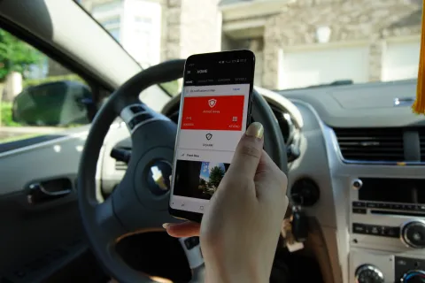 a hand holding a phone in a car