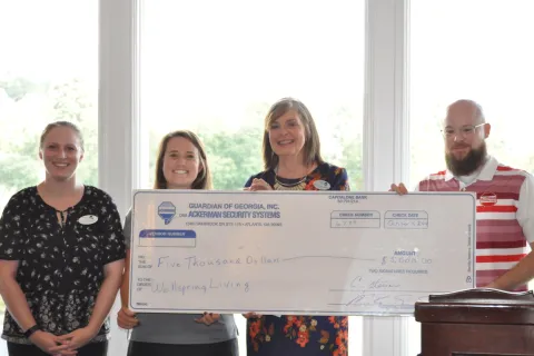 a group of people holding a big check