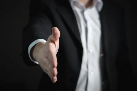 a man in a suit giving a handshake