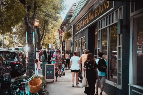 Busy sidewalk outside Virginia Highland Books with people walking by on a sunny day
