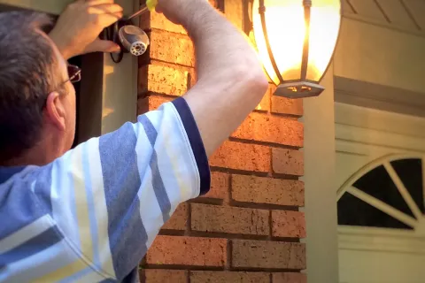 a man taking installing an outdoor camera