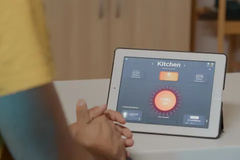 a person controlling lights through a tablet