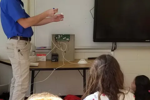 a person teaching a group of children