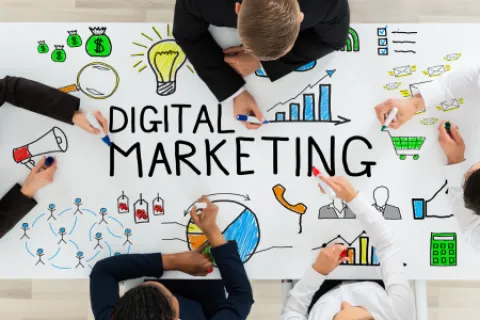 Top view of professionals drawing digital marketing concepts like graphs, lightbulb, shopping cart on white board.