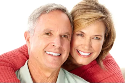 Happy middle-aged couple smiling and embracing each other with a white background