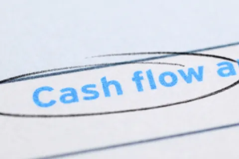 Close-up of paper with 'Cash flow analysis' text circled in black pen on white background.