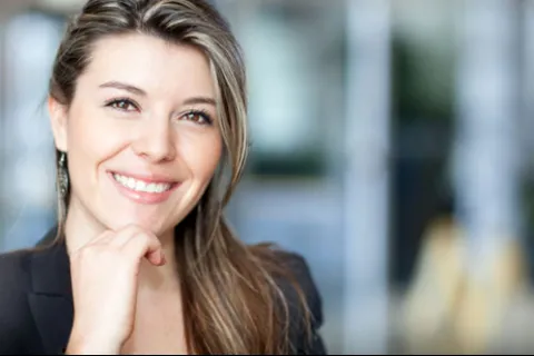 Smiling woman in a professional setting, showcasing confidence and approachability.