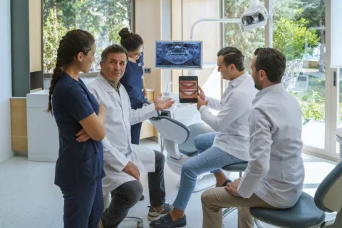 Dental professionals discussing treatment plans in a modern clinic setting.