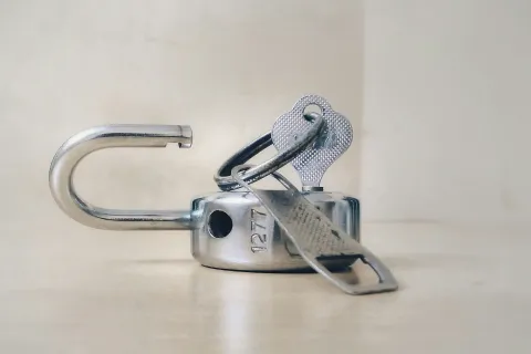 Man cutting rope tying large ball at cliff edge causing break and risk of falling down.