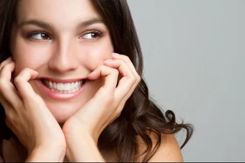 Close-up of a smiling woman with long hair expressing joy and warmth.