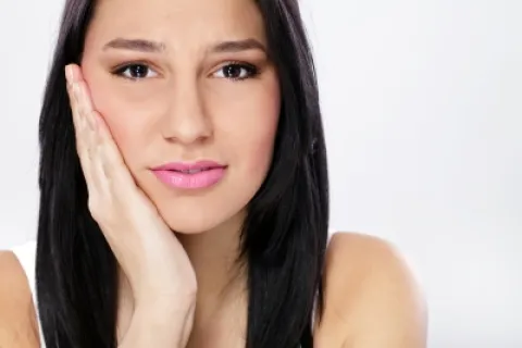 Young woman with long black hair expressing concern or contemplation on a white background.