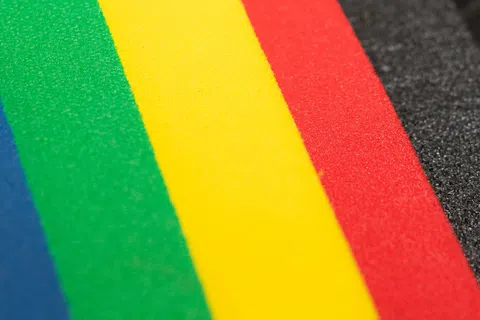 Close-up of colorful foam sheets in blue, green, yellow, red, and black foam with textured edges.