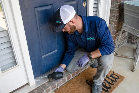 A technician installing a door component with a drill, showcasing home improvement services.
