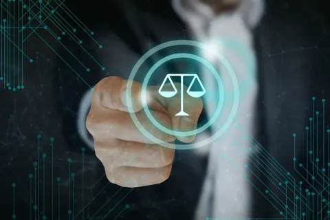 Hand pointing to digital scales of justice icon representing law and legal technology concept