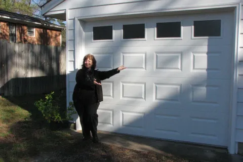 a man standing next to a white building