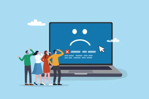 Four people looking confused at a laptop showing a blue screen with a sad face and error message