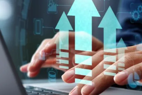 Hands typing on laptop keyboard with digital arrows pointing upward symbolizing growth and progress