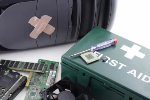 Computer repair concept with PC tower, electronic components, green first aid kit, and a screwdriver on white background.