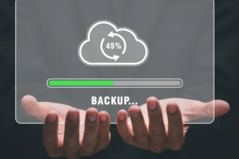 Hands holding a digital backup progress bar at 45% with a cloud sync icon in a business suit background