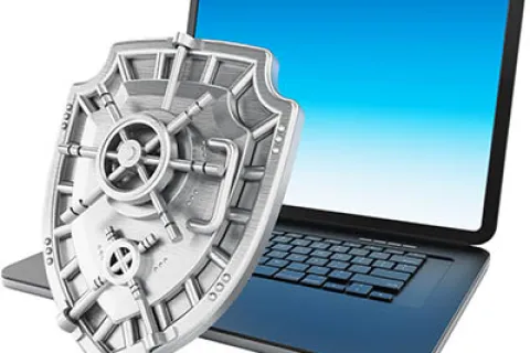 Laptop with a large metallic shield representing cybersecurity and data protection concept.