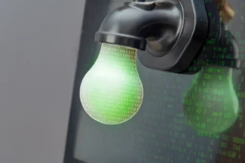Digital light bulb made of binary code attached to faucet on laptop screen representing data flow and innovation.