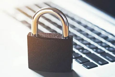 Black padlock placed on a laptop keyboard symbolizing cybersecurity and data protection concepts.