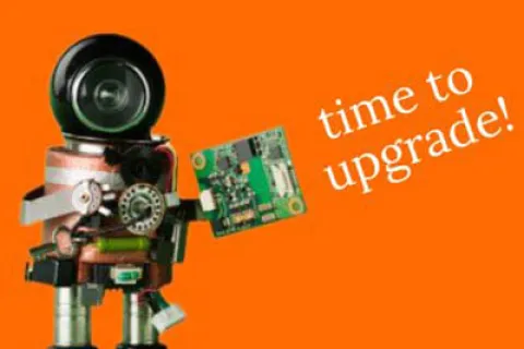 Robot holding a circuit board with text time to upgrade on an orange background