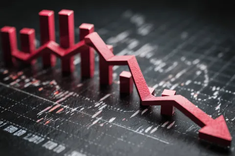 Red downward arrow graph on black financial chart representing economic decline or stock market drop.
