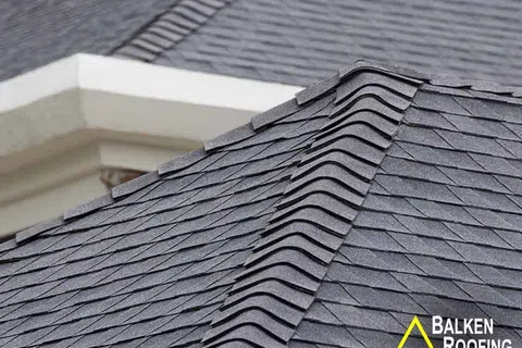 Close-up of dark gray asphalt shingle roofing with clean, overlapping rows on a residential roof.