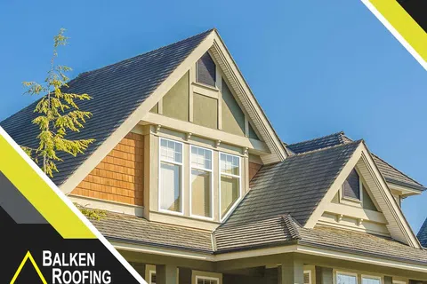 Modern house roof with shingles under clear blue sky featuring Balken Roofing logo