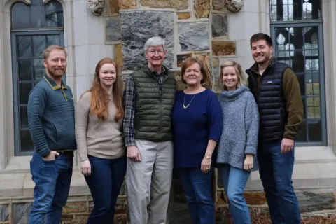 Sue Tarpley and her family pose in front of a brick building
