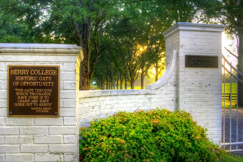 Berry College's Historic Gate of Opportunity at sunrise, showcasing scenic trees and inviting entrance.