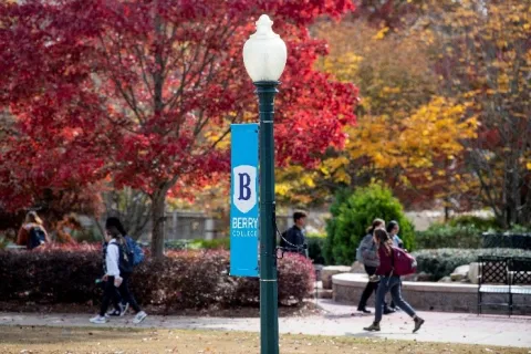 Berry College Logo on a Lamp Post in Front of Fall-Colored Trees