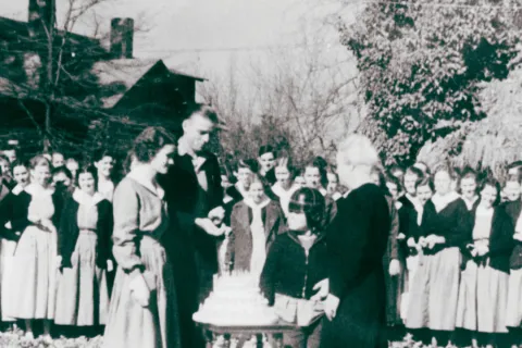 a group of people standing around a table