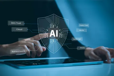 Person interacting with a tablet displaying an AI shield surrounded by cybersecurity and technology terms.
