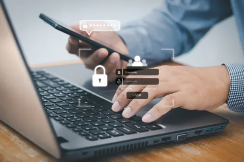 Person logging into a laptop and smartphone with secure password and login interface icons visible.