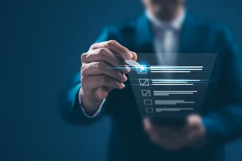 Businessman in suit interacting with a futuristic digital checklist interface with glowing checkboxes.