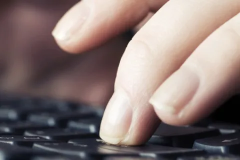 close-up of hands typing on a keyboard