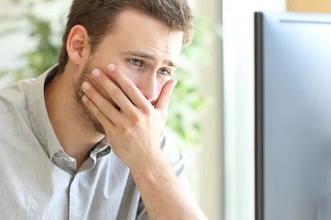 a man with his hand on his face