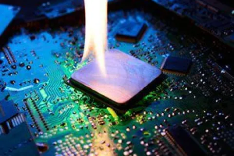 Microchip on a circuit board with a flame burning on top, symbolizing overheating or hardware failure.