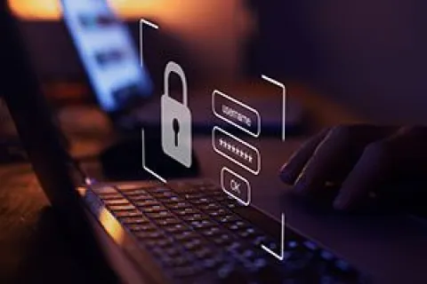 User entering password on laptop with digital lock icon representing cybersecurity and data protection.