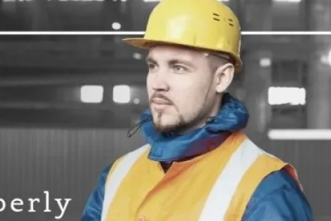 Construction worker in safety gear holding documents in an industrial setting with training tips text overlay.