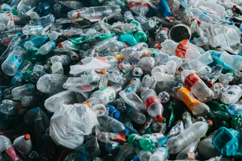 Large pile of discarded plastic bottles and containers in an outdoor setting highlighting environmental pollution.