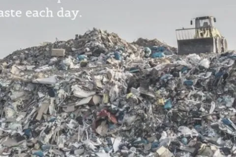 Large landfill pile of mixed solid waste with a bulldozer on top and text about daily waste production.