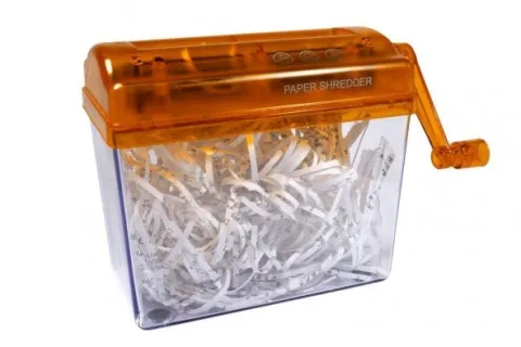 Orange-handled manual paper shredder filled with shredded white paper strips against white background