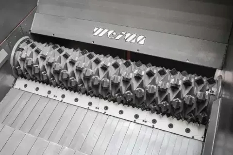 Close-up of industrial metallic shredding machine components with sharp, interlocking teeth inside a stainless steel casing.